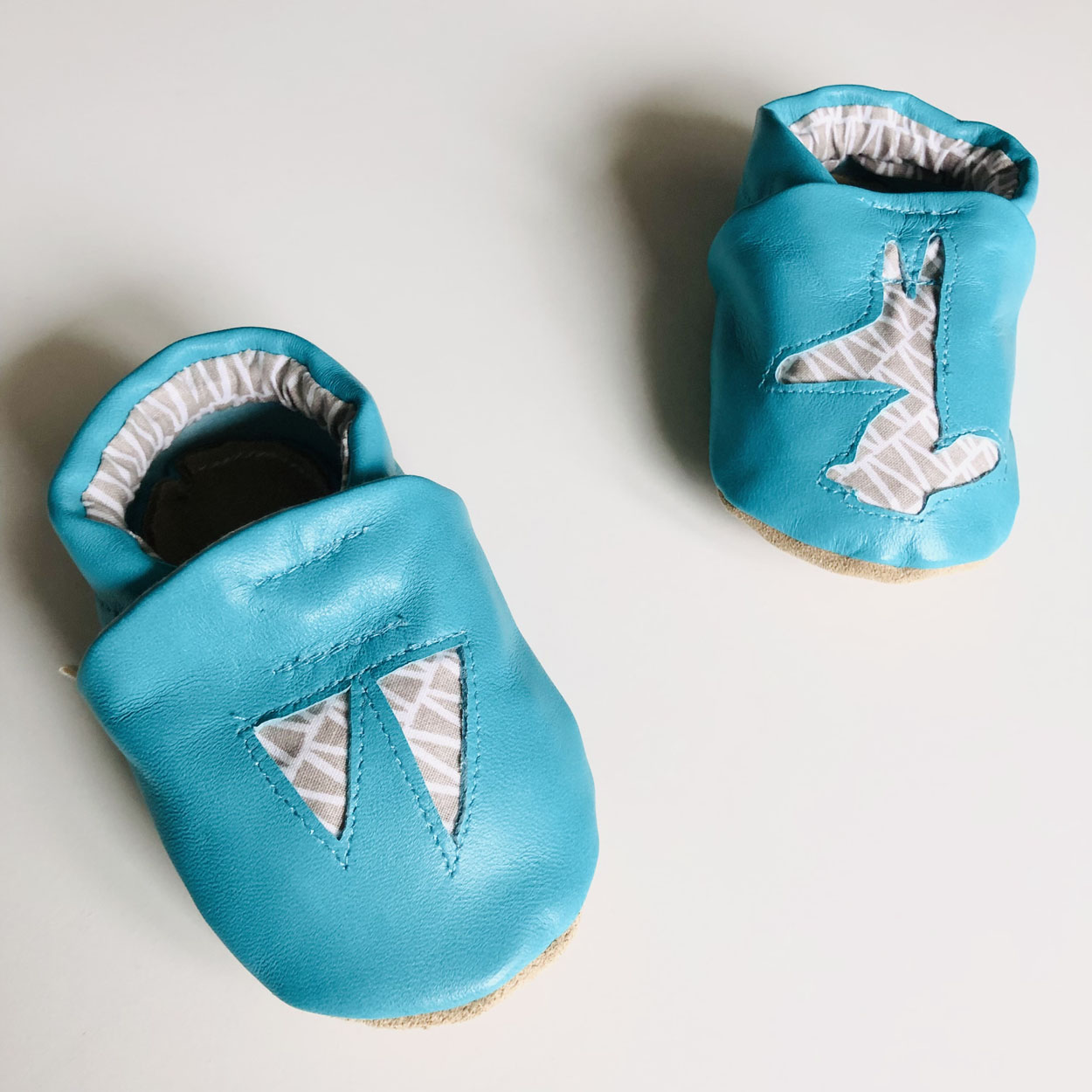 Chaussons bébé en cuir bleu motifs graphiques gris