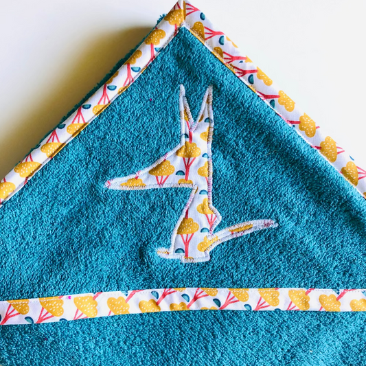 cape de bain et gant bleu arbres