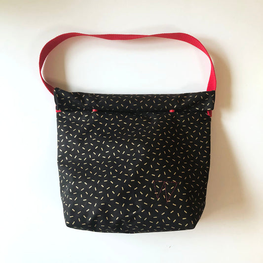 Lunch bag enduit noir à motifs dorés